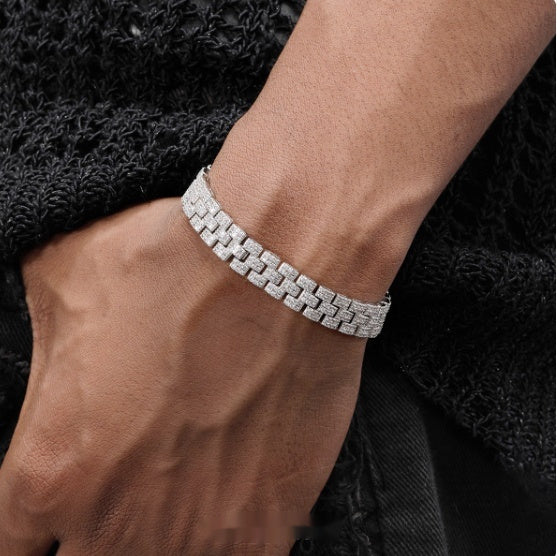 Silver bracelet on a wrist with a dark textured background