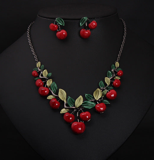 Necklace and earrings set with cherry design on a black background