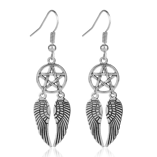 Silver earrings with wing and pentagram designs on a white background