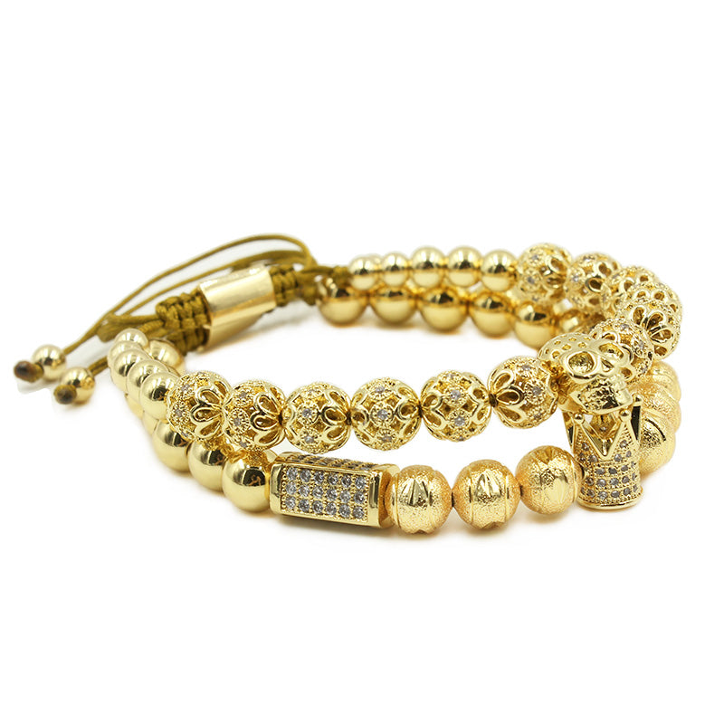 Gold beaded bracelet with skull design on a white background