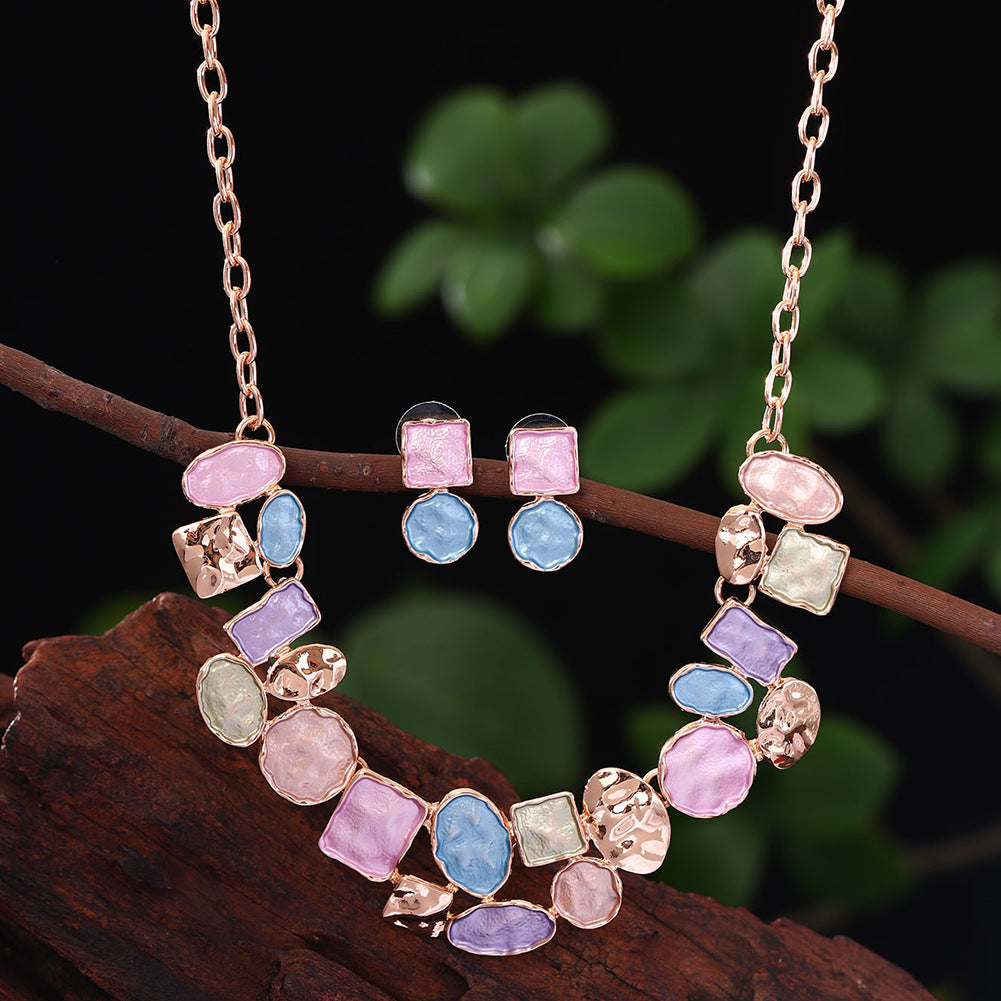 Necklace with colorful gemstones on a branch against a blurred green background