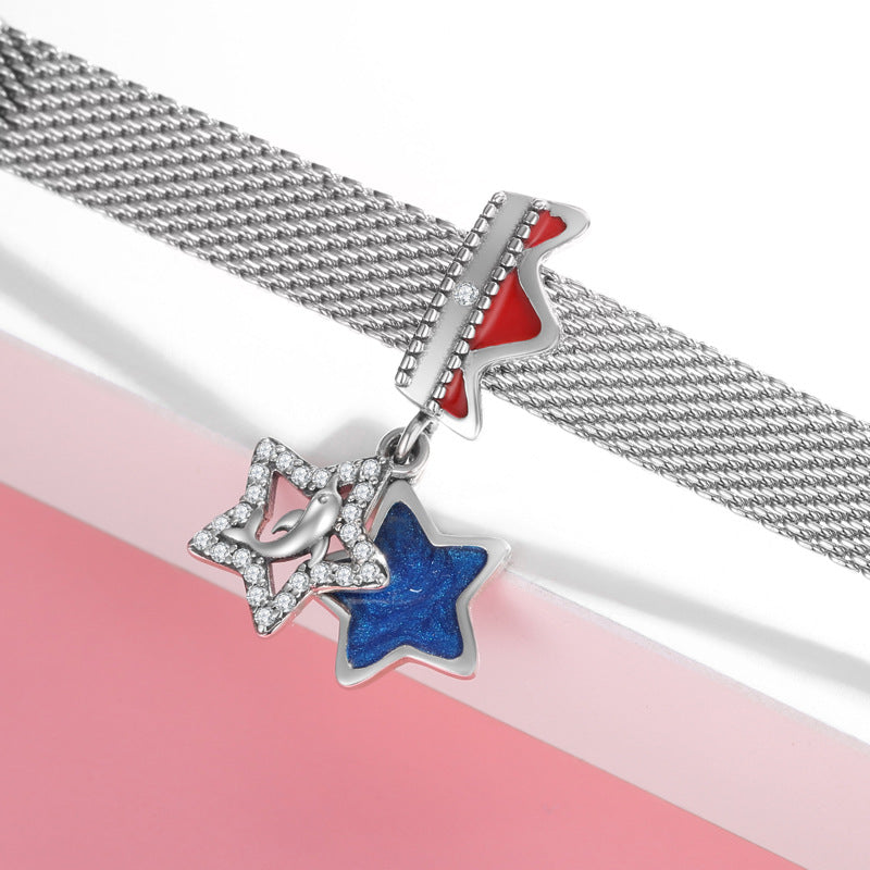 Silver chain bracelet with star-shaped charms on a pink and white background