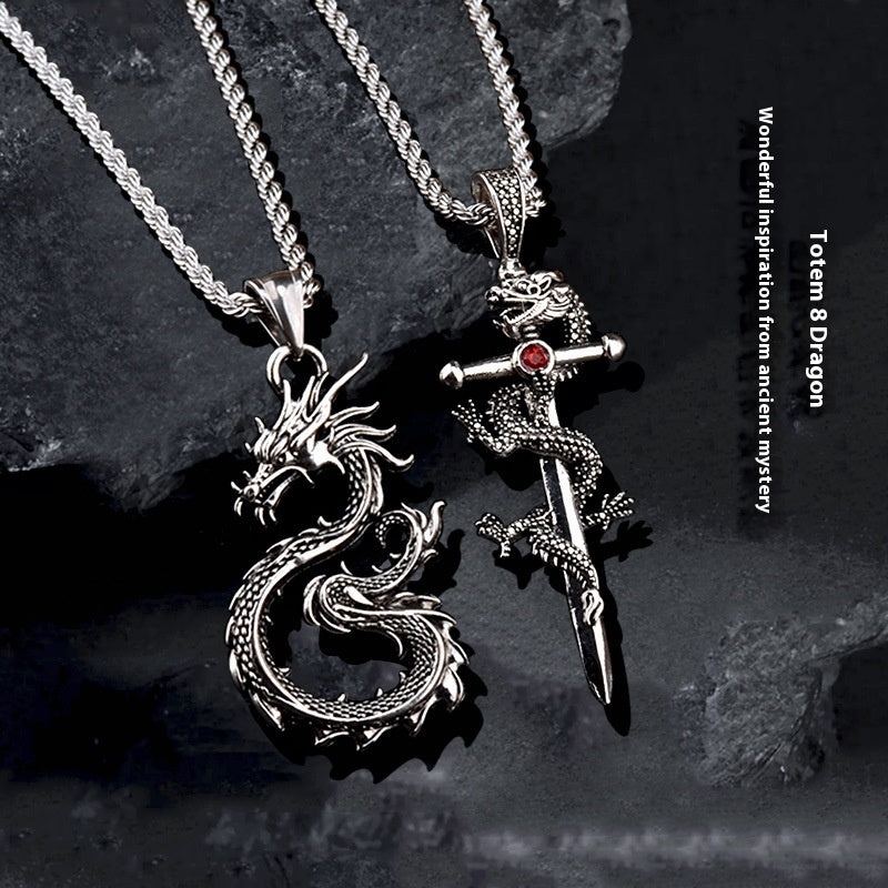Two silver dragon pendants on dark stone background