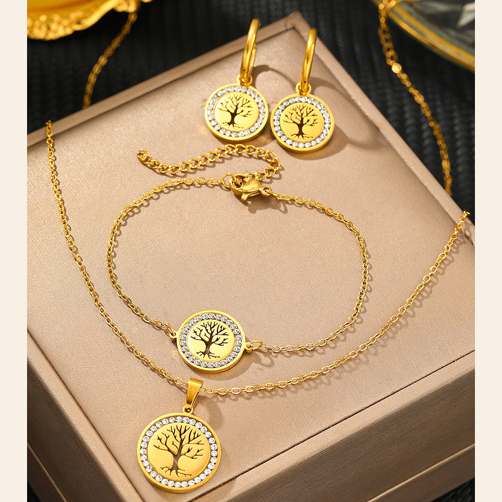 Gold jewelry set with necklace, earrings, and bracelet on a beige surface