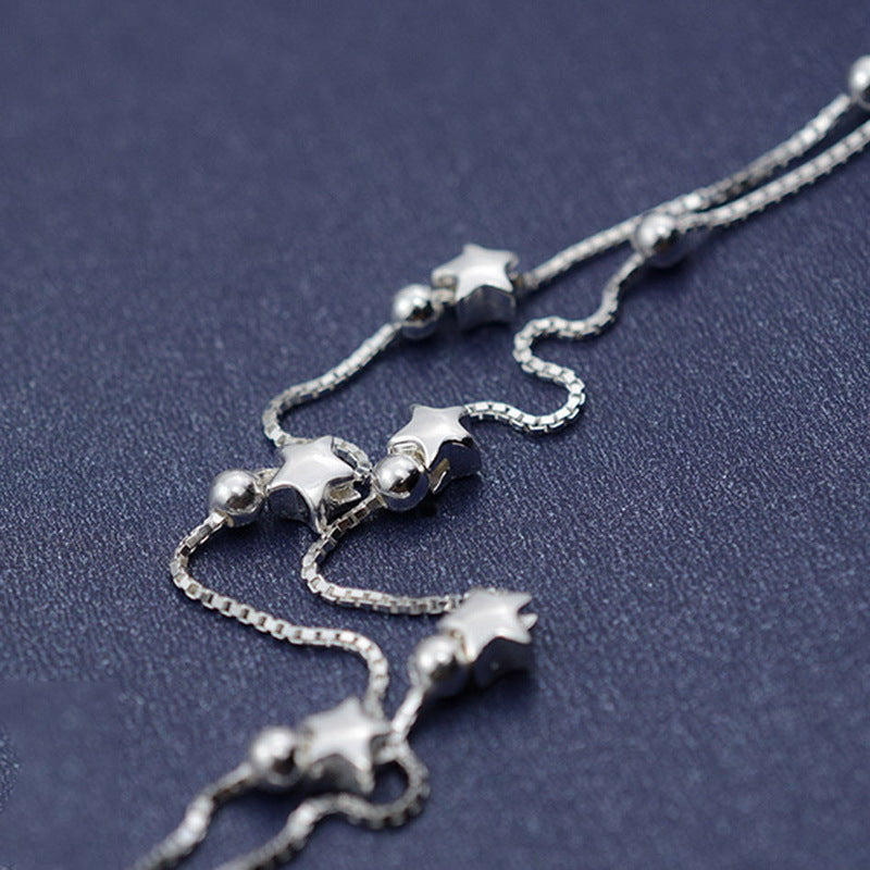 Silver star-shaped bracelet on a dark blue background