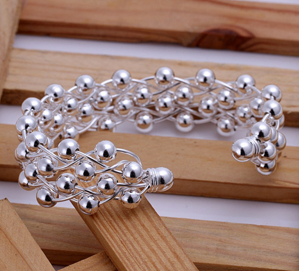 Silver beaded bracelet on a wooden surface