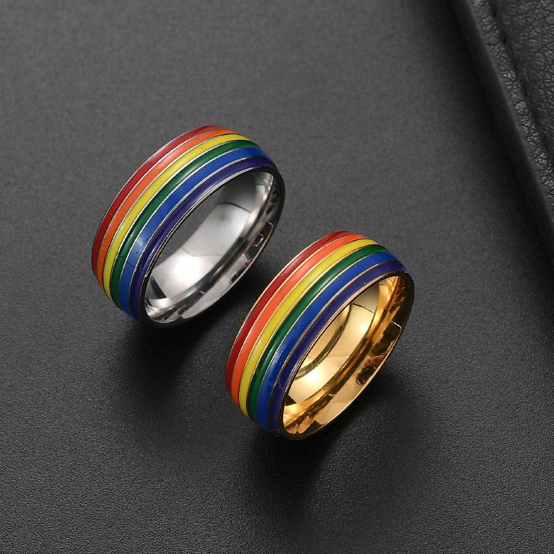 Two rainbow-striped rings on a dark gray surface