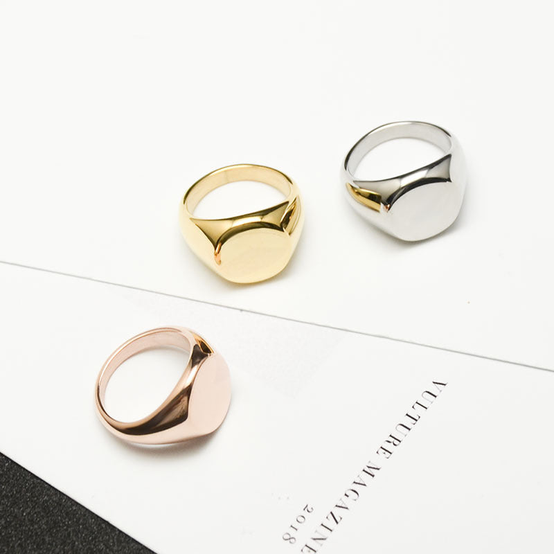 Three metallic rings in gold, rose gold, and silver on a white surface with text.
