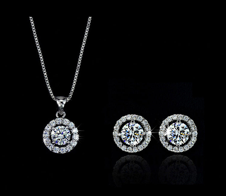 Silver jewelry set with necklace and earrings on a black background