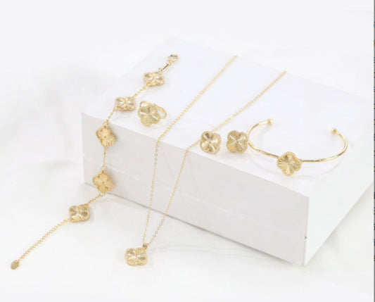 Set of gold jewelry including necklace, earrings, and bracelet on a white background