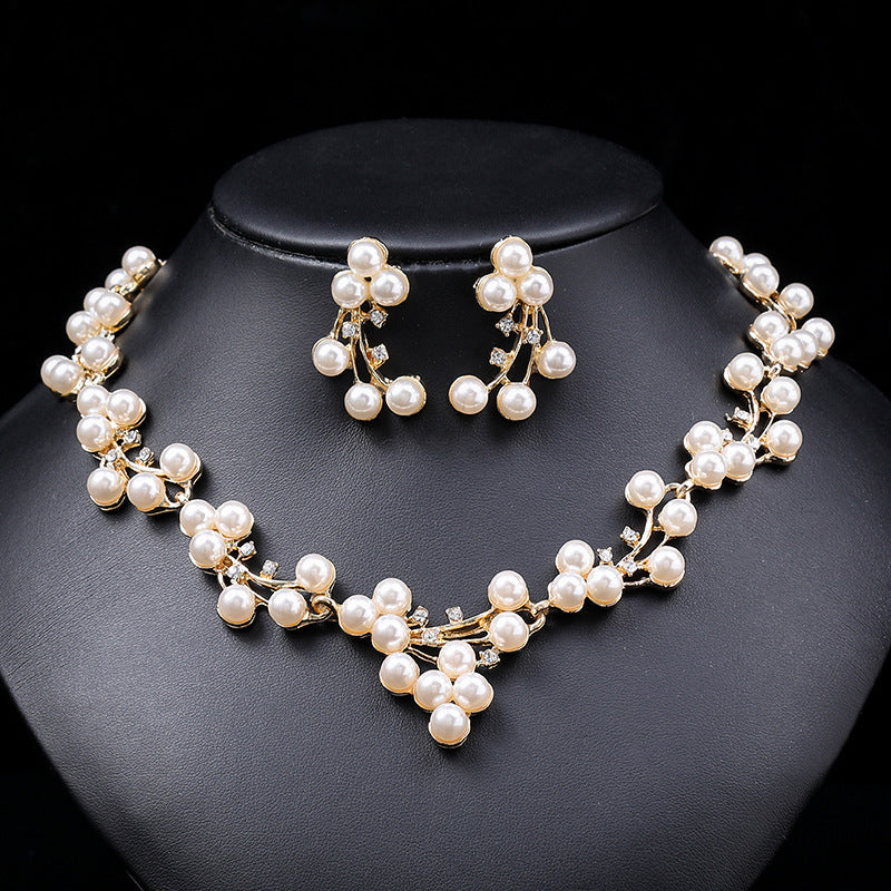Pearl necklace and earrings set on a black background