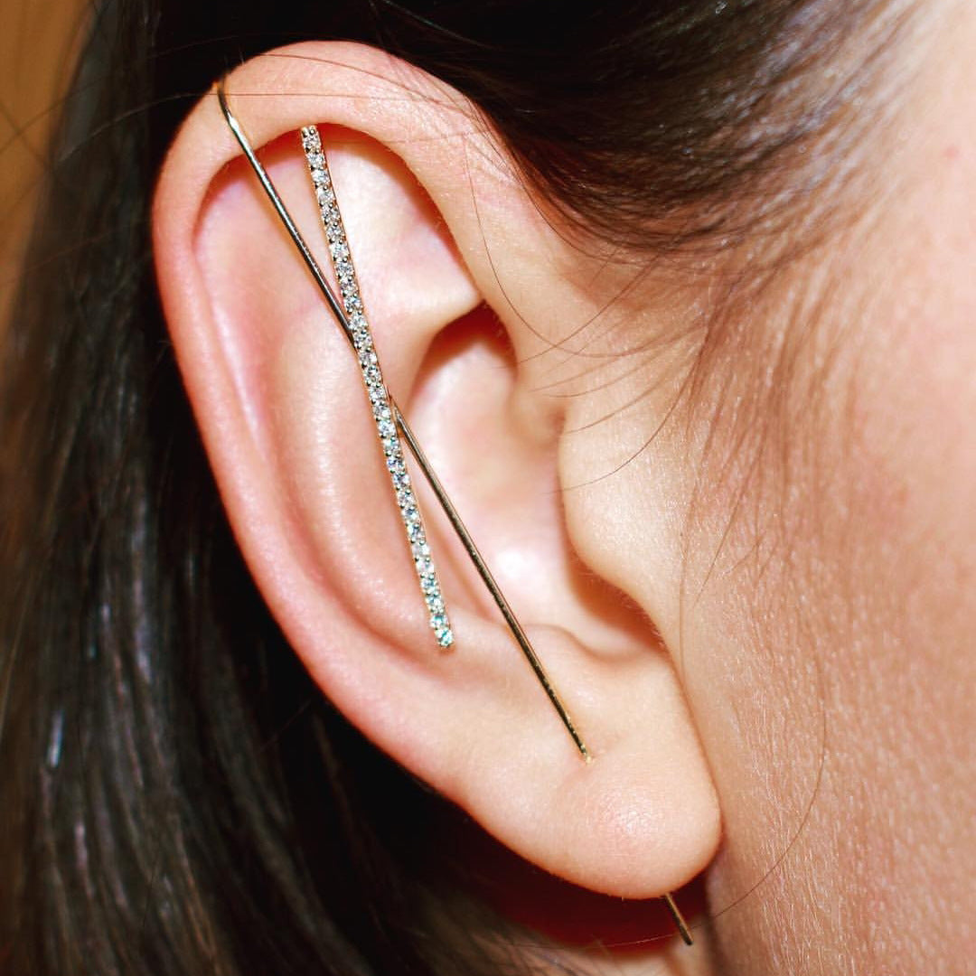Close-up of an ear with a delicate silver earring.