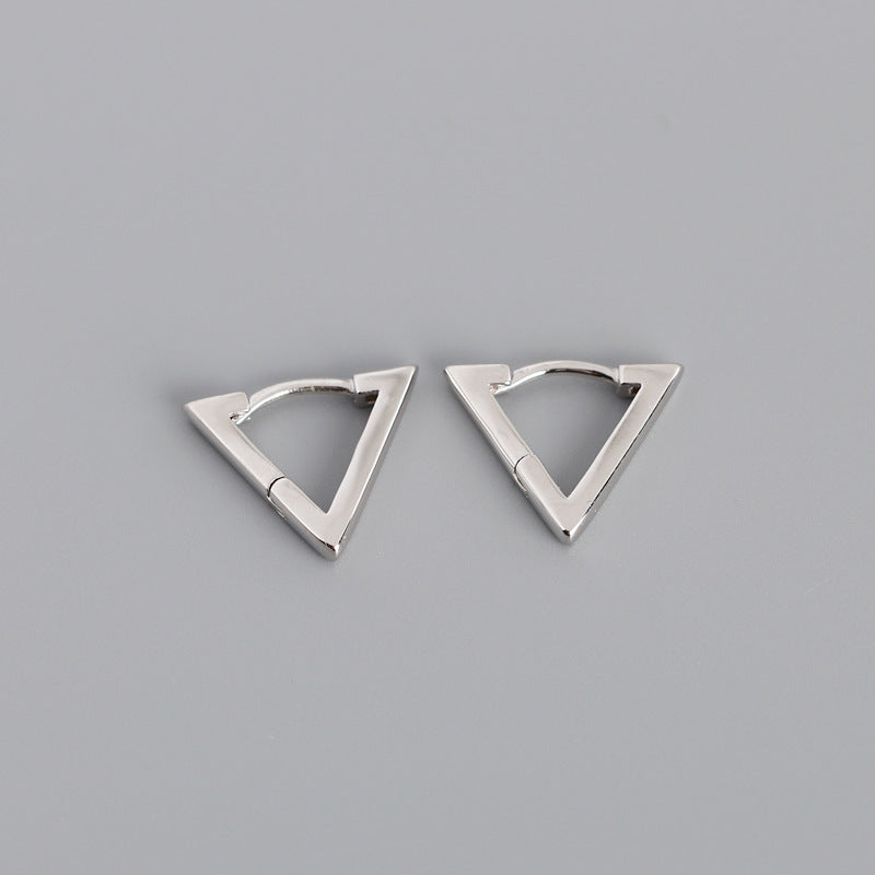 Pair of silver triangle-shaped earrings on a gray background