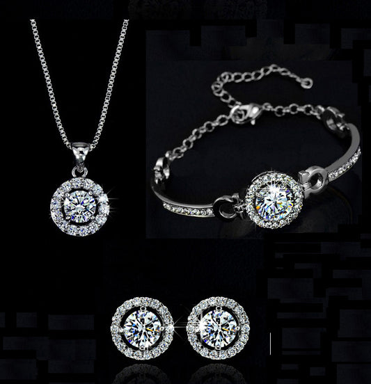 Silver jewelry set with necklace, bracelet, and earrings on a black background