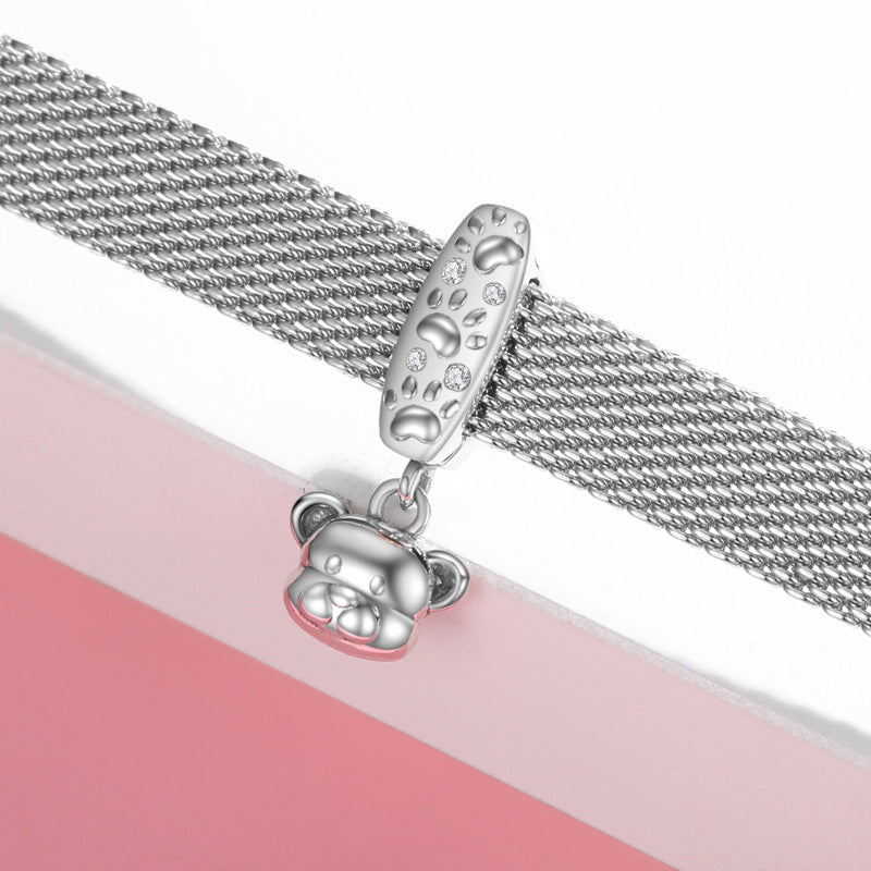 Silver chain with a bear charm on a pink and white background