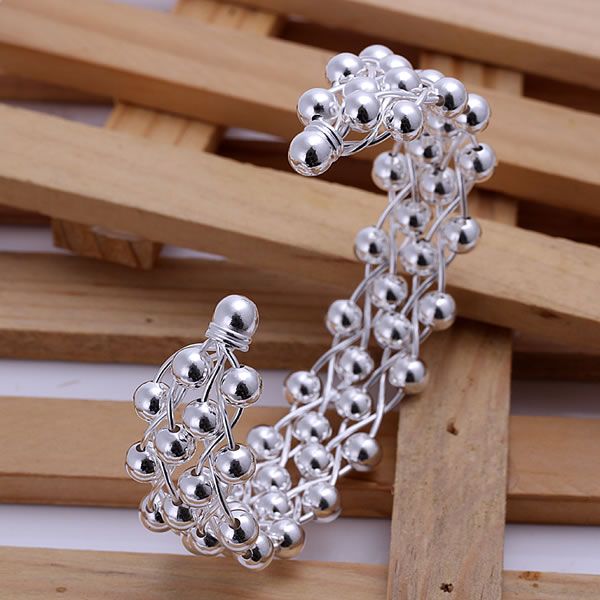 Silver beaded earrings on a wooden surface