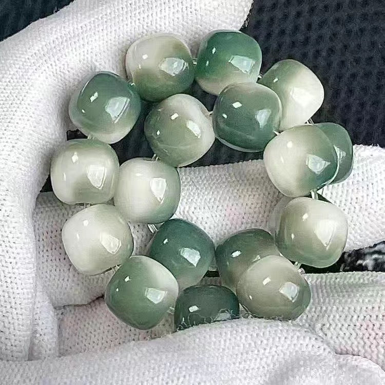 Green jade beads on a white fabric background
