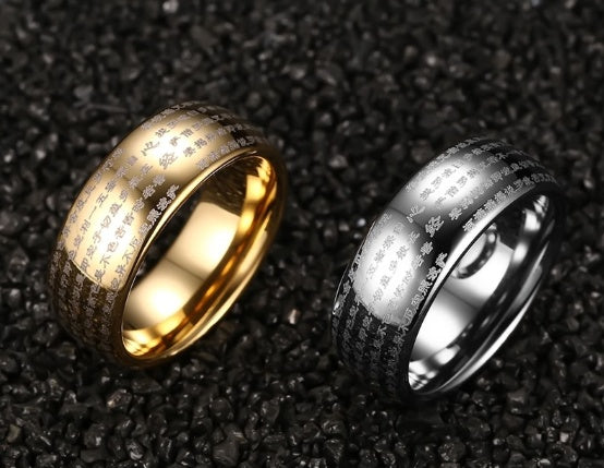 Gold and silver rings with engraved patterns on a dark textured background