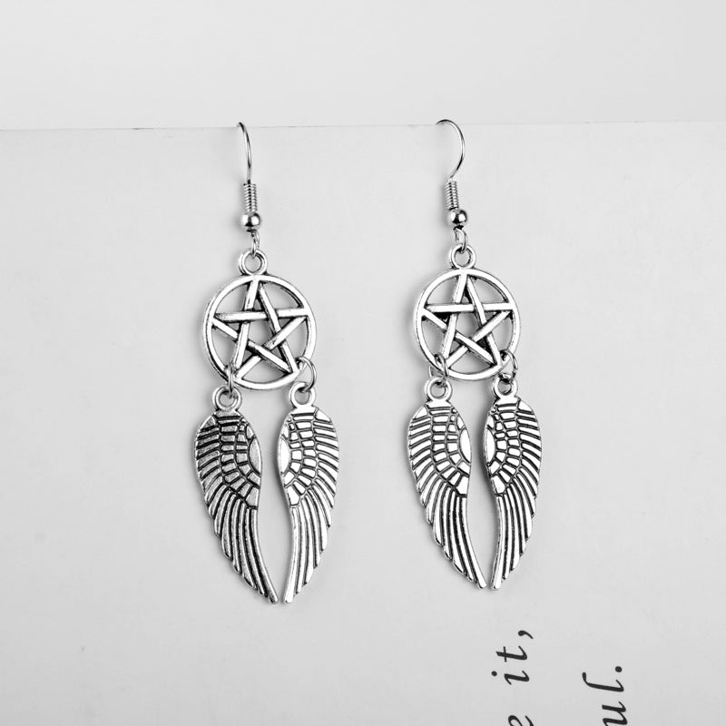 Silver winged earrings with pentacle design on a white background