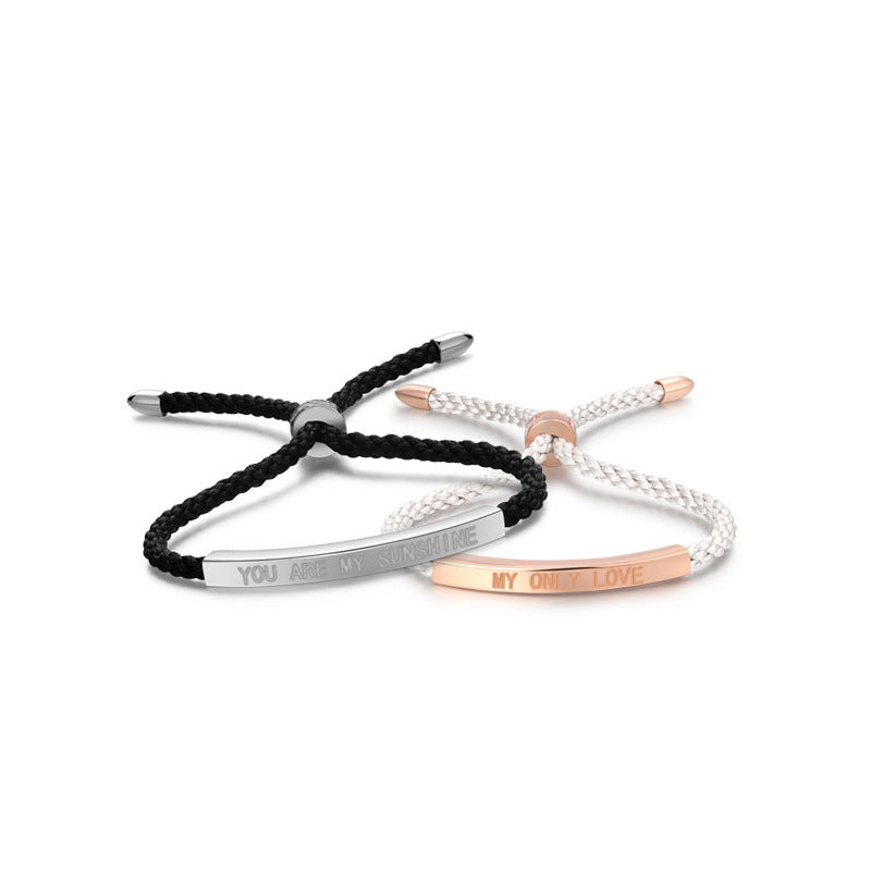 Two bracelets, one black and silver, the other rose gold and white, on a white background.