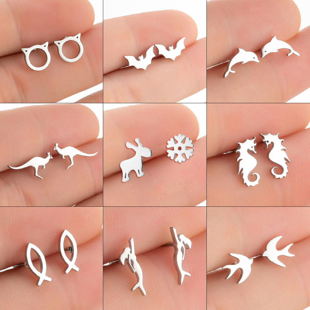 Collection of various silver animal-shaped earrings on a person's hand.
