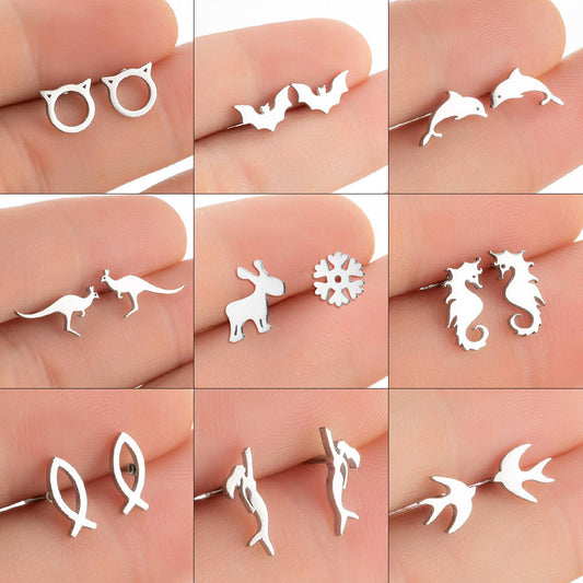 Collection of various silver animal-shaped earrings on a person's hand.