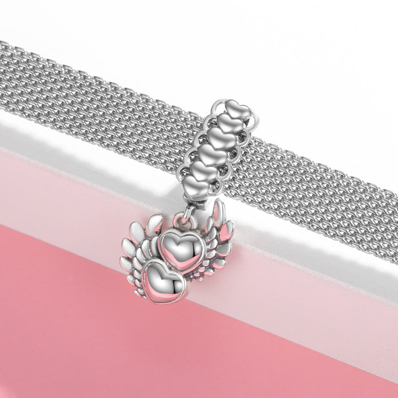 Silver charm with heart design on a pink and white striped background
