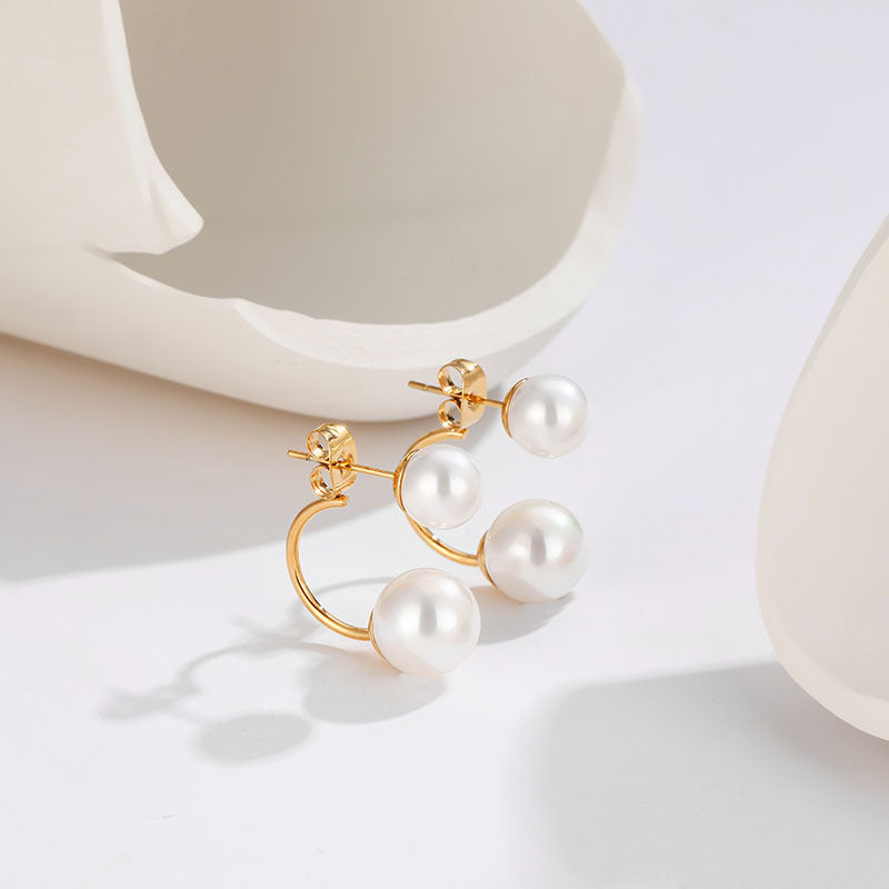 Pearl earrings with gold accents on a light background
