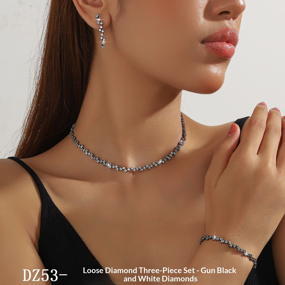 Woman wearing a loose diamond three-piece set with gun black and white diamonds, including earrings and a necklace.