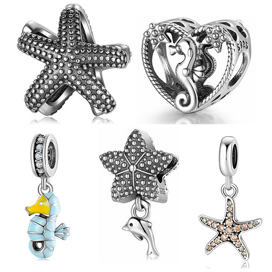Collection of silver charms including starfish, seahorse, and fish on a white background