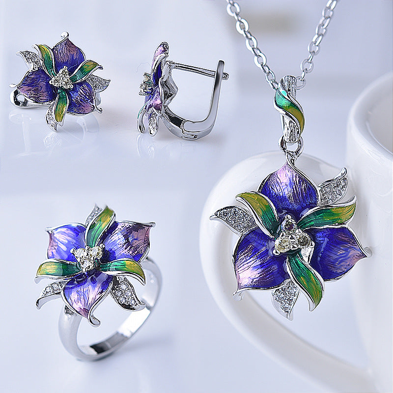 Floral jewelry set with ring, earrings, and necklace on a white background