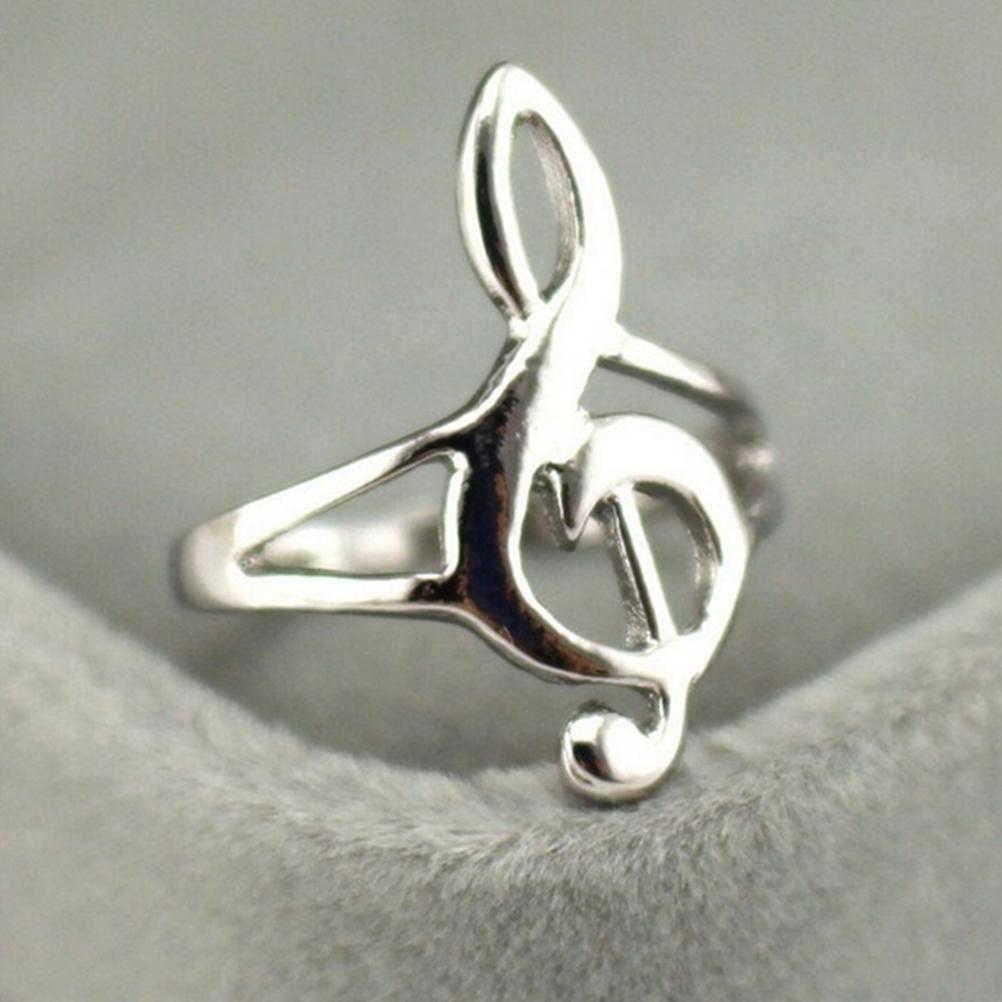 Silver treble clef ring on a gray background