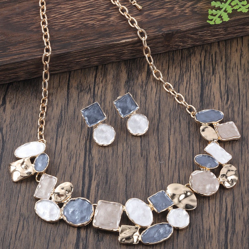 Necklace and earrings set with stone-like beads on a wooden surface