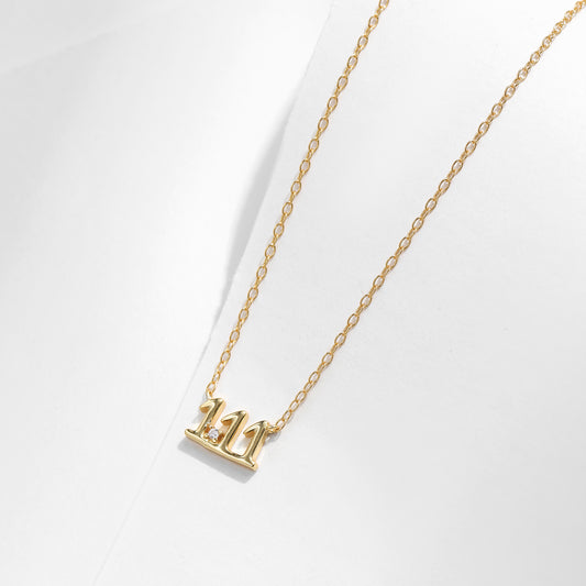 Gold necklace with a small pendant on a white background