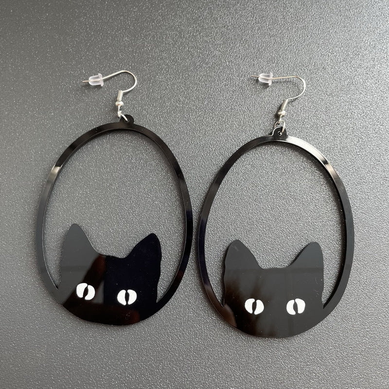Black cat-shaped earrings on a gray background