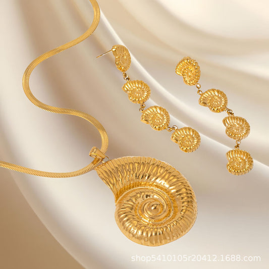Gold necklace and earrings on a beige fabric background