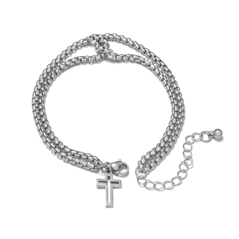 Silver chain bracelet with a cross pendant on a white background