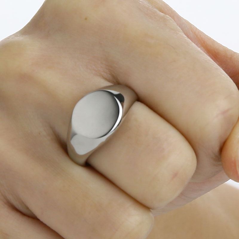 Silver ring on a person's finger with a plain background