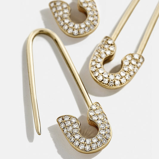 Gold earrings with clear gemstones on a white background