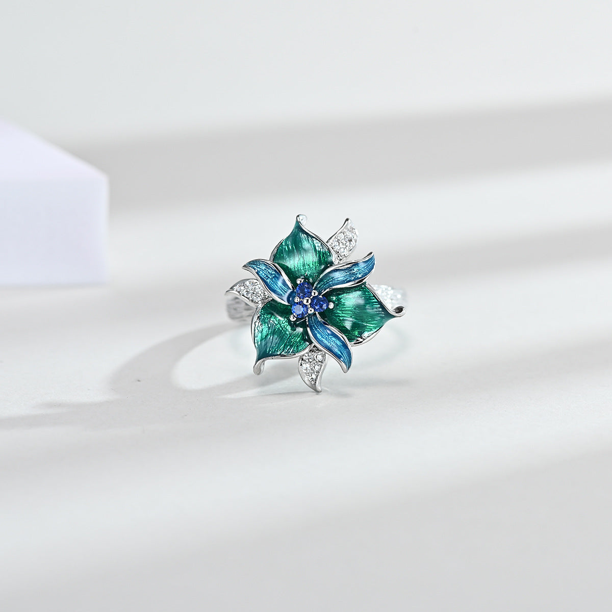 Decorative ring with green and blue floral design on a white background