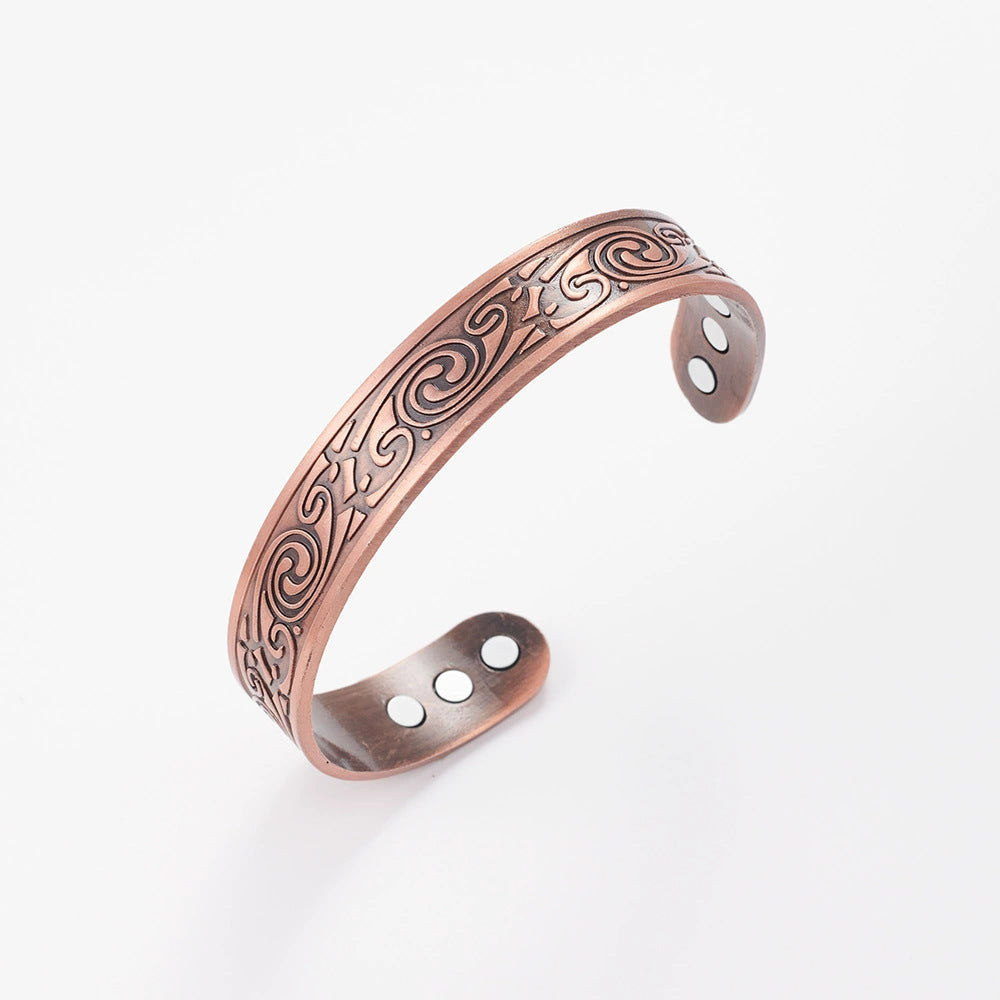 Copper bracelet with intricate designs on a white background