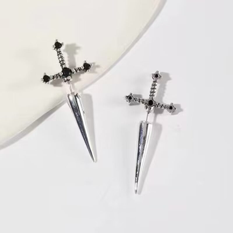 Sword-shaped earrings with black gemstones on a white background