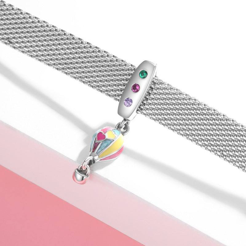 Silver bracelet with a colorful charm on a white background