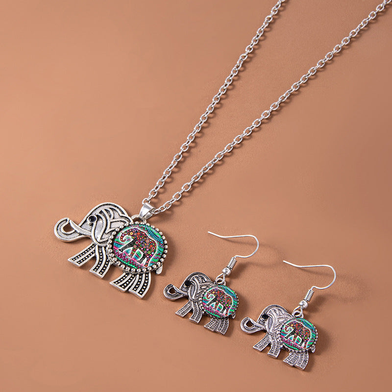 Jewelry set with elephant pendant necklace and earrings on a brown background