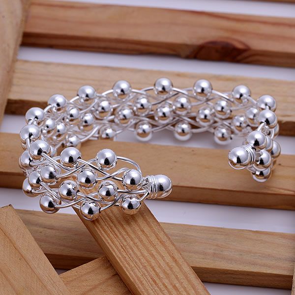 Silver beaded bracelet on a wooden surface