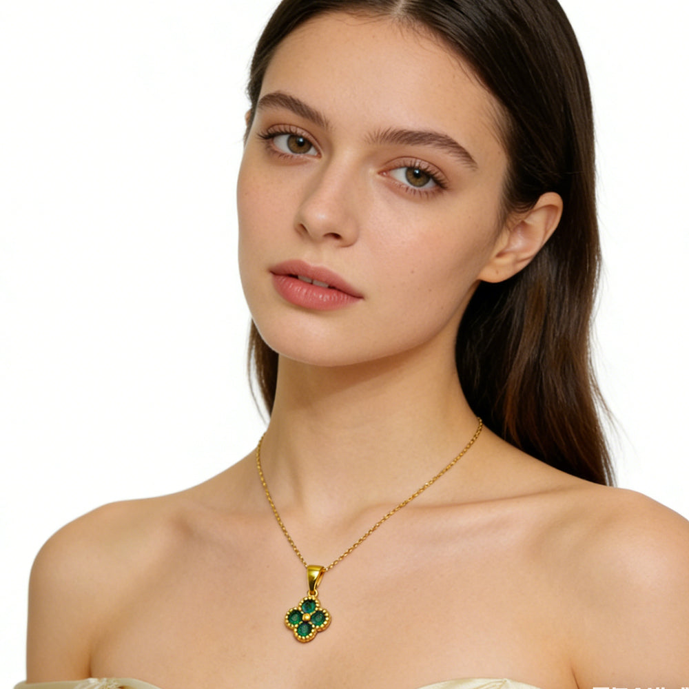 Woman wearing a gold necklace with a green pendant on a white background