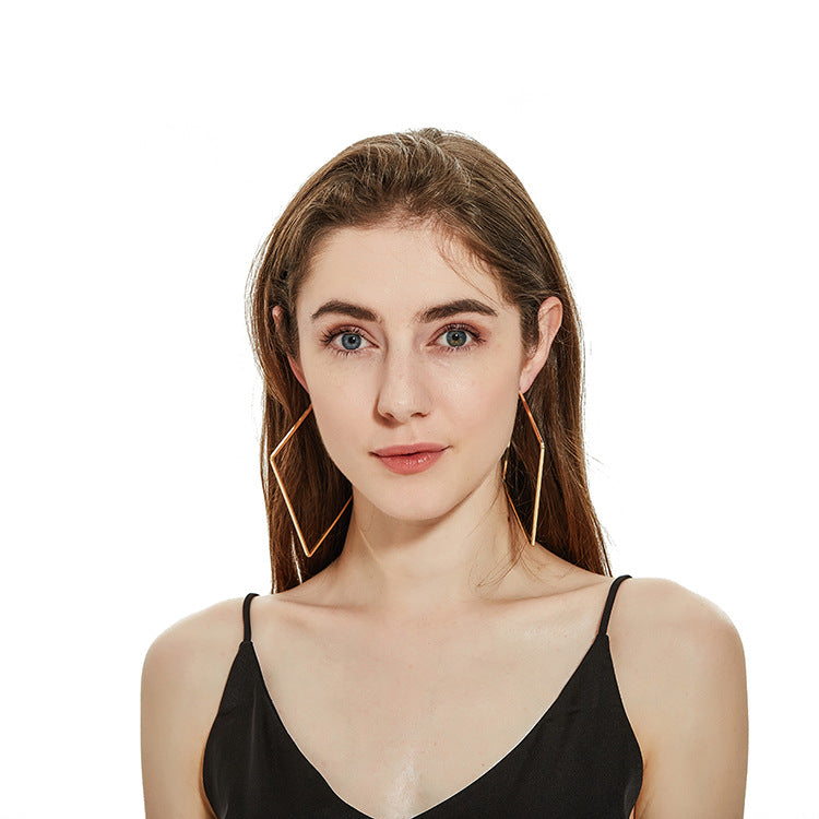 Woman wearing gold hoop earrings on a white background