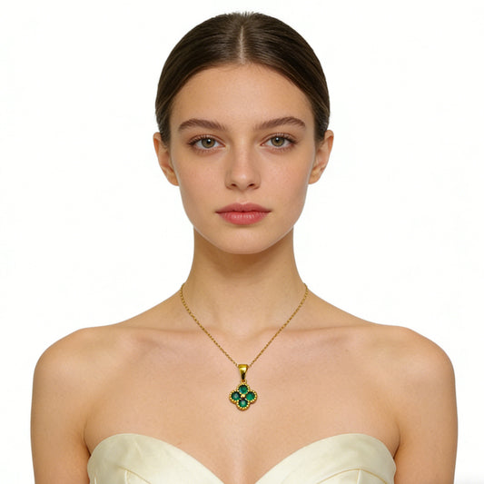 Woman wearing a gold necklace with a green pendant on a white background