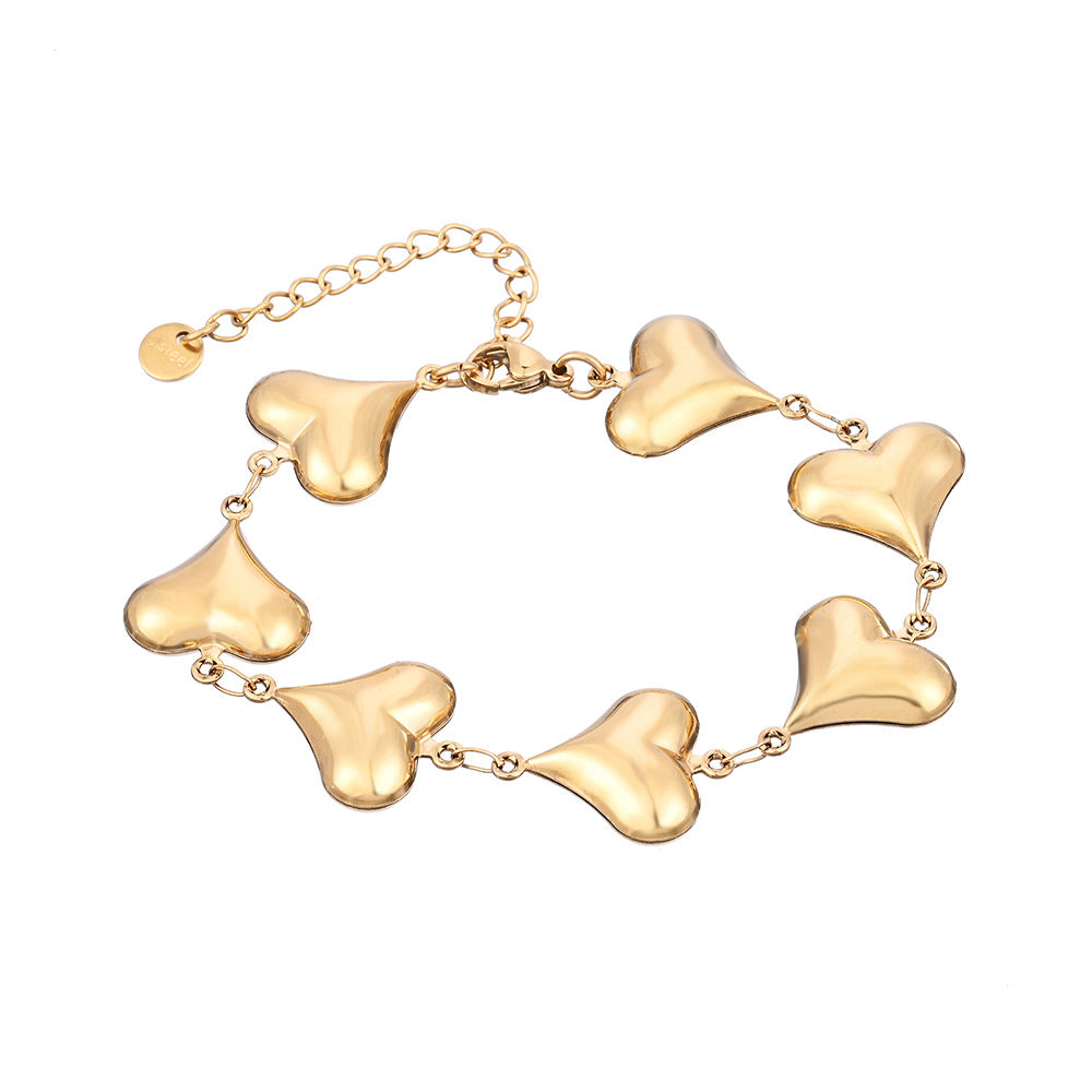Gold bracelet with heart-shaped links on a white background