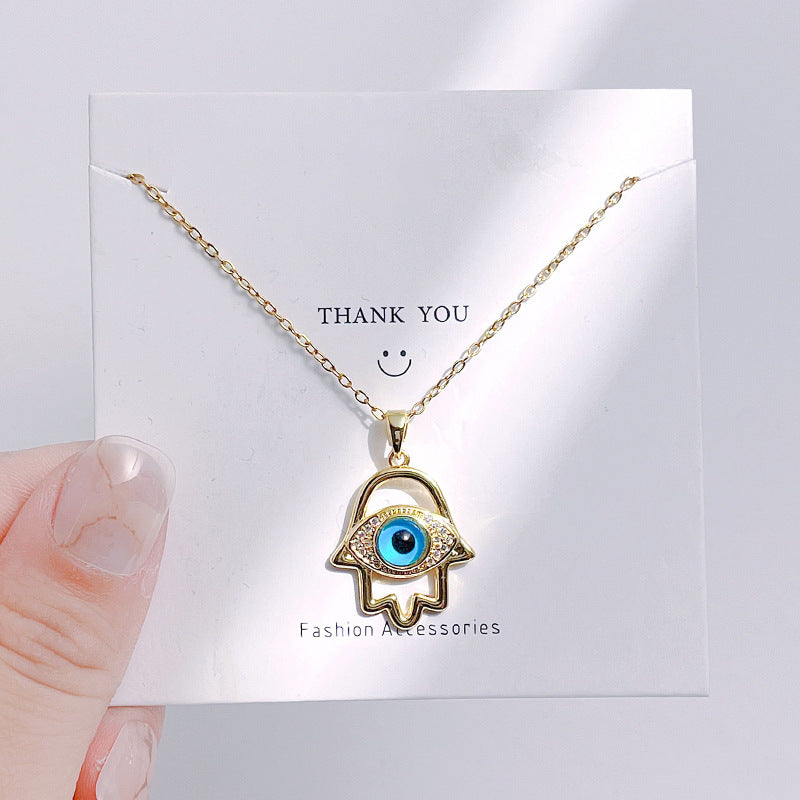 Gold necklace with eye pendant on a 'Thank You' card